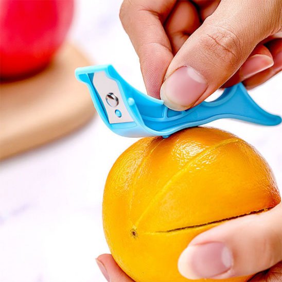 Eplucheur manuel découpant une orange