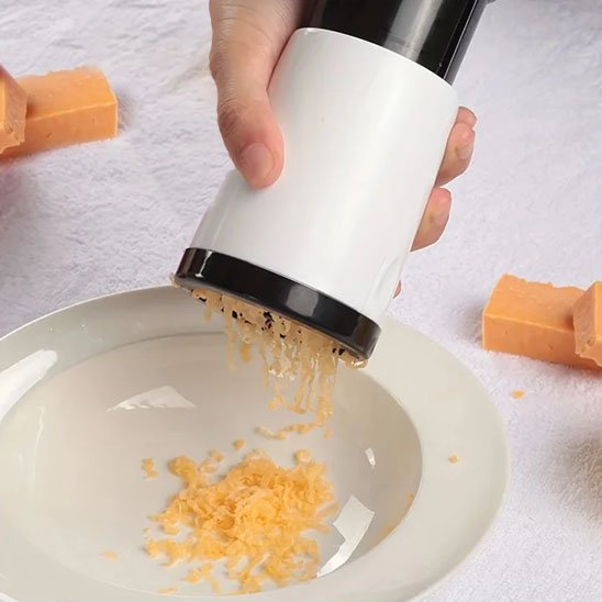 Râpe à fromage avec morceau de fromage en action