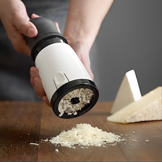 râpe à fromage en action sur un morceau de fromage dur